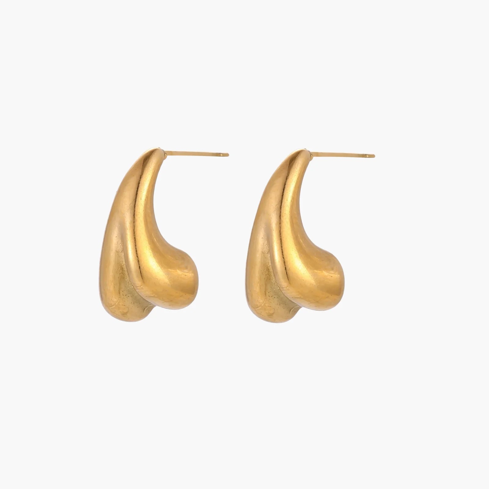 Pair of sculptural gold stud earrings with twisted organic forms on cream background