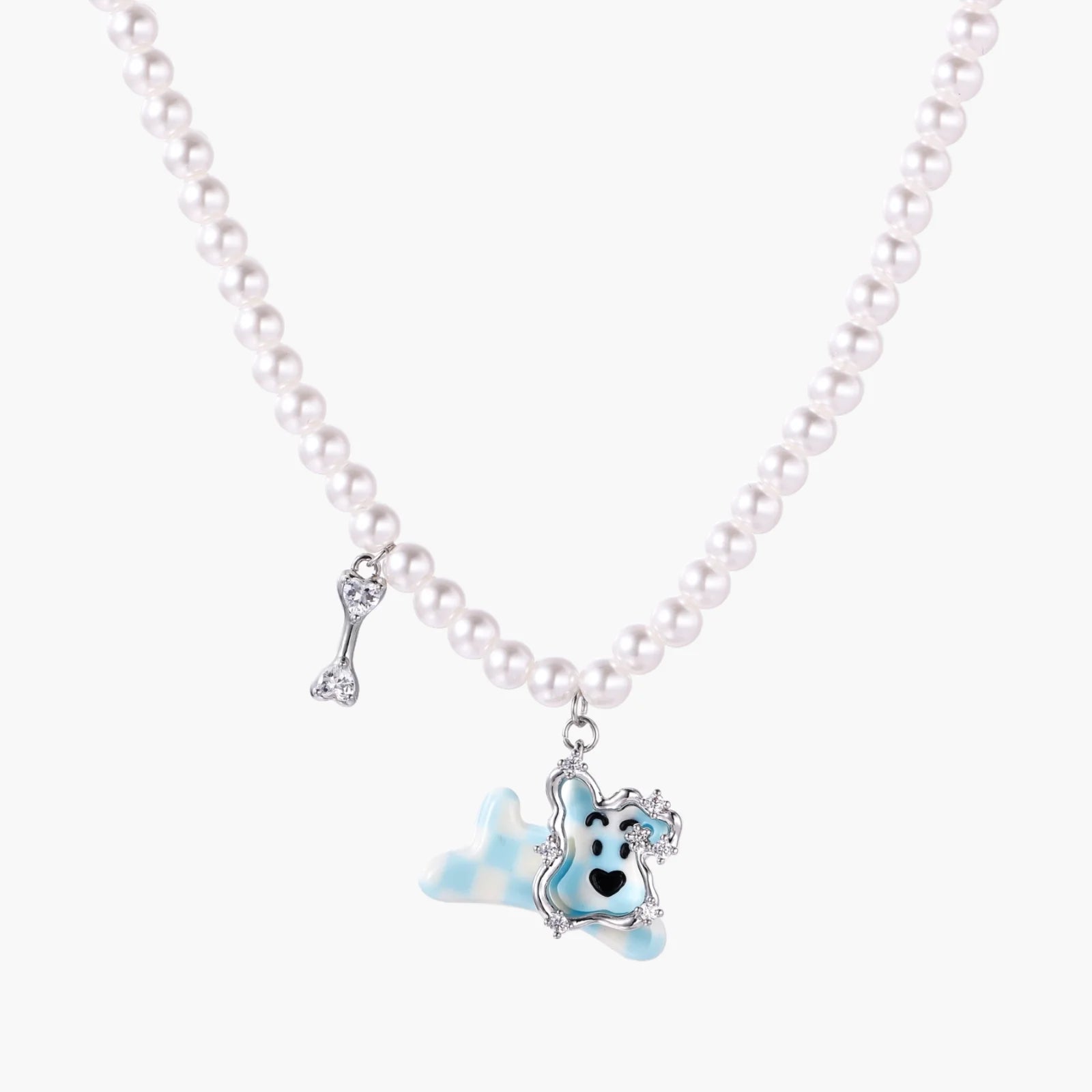 Pearl necklace with playful blue dog pendant accented with sparkly crystals on cream background.