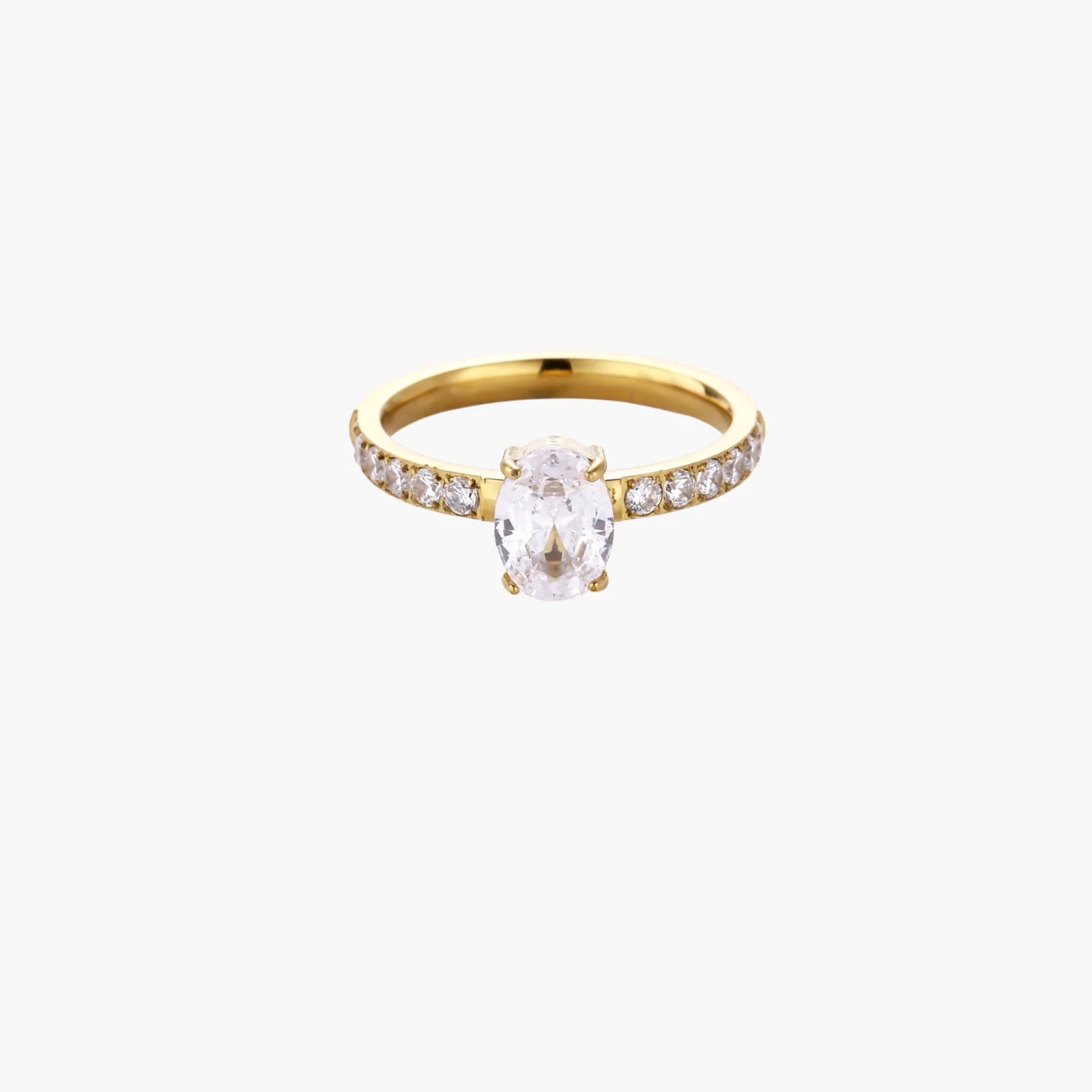 Gold-plated solitaire ring with oval zirconia center stone and pavé band on cream background