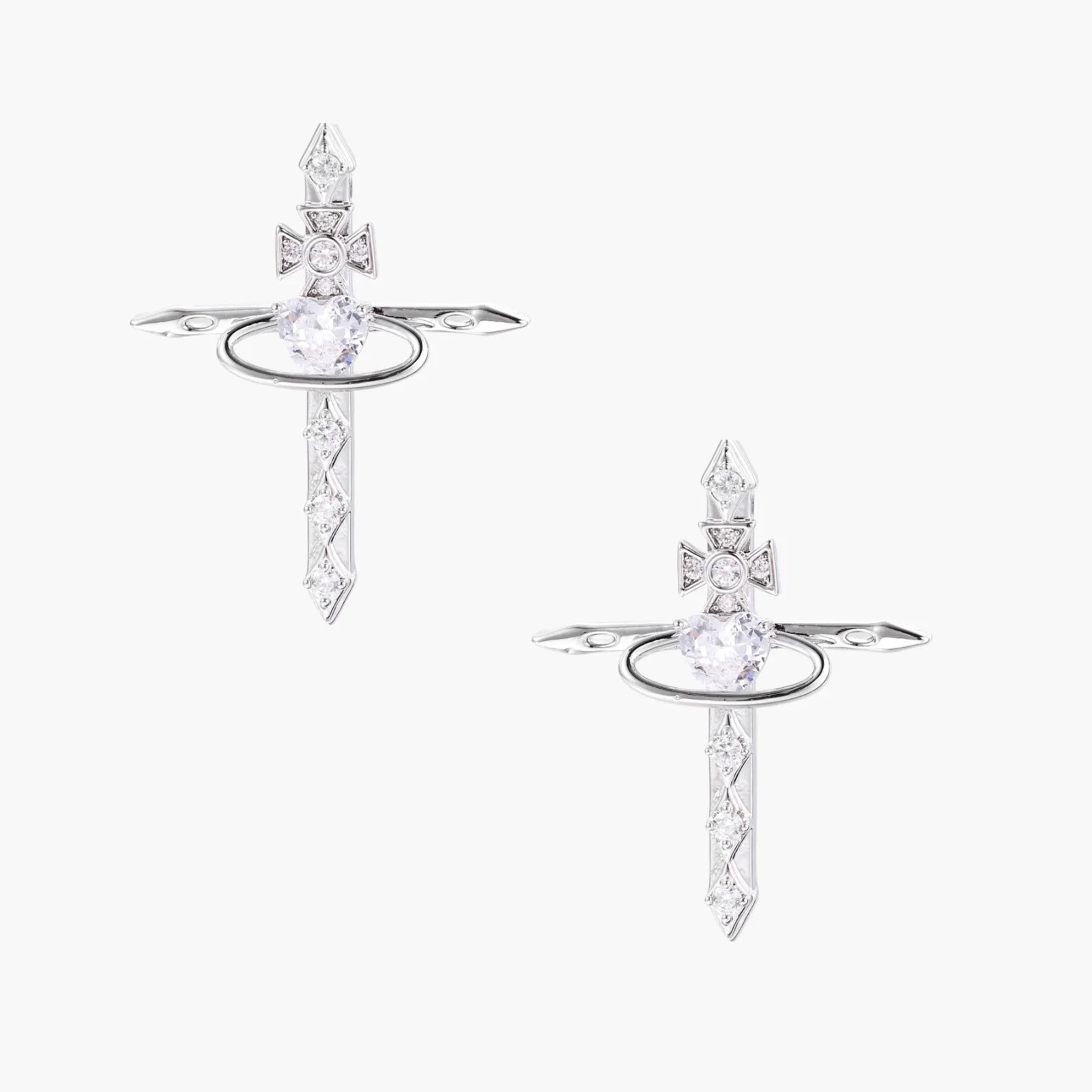 White gold plated cross earrings with orbital ring & zirconia stones on cream background