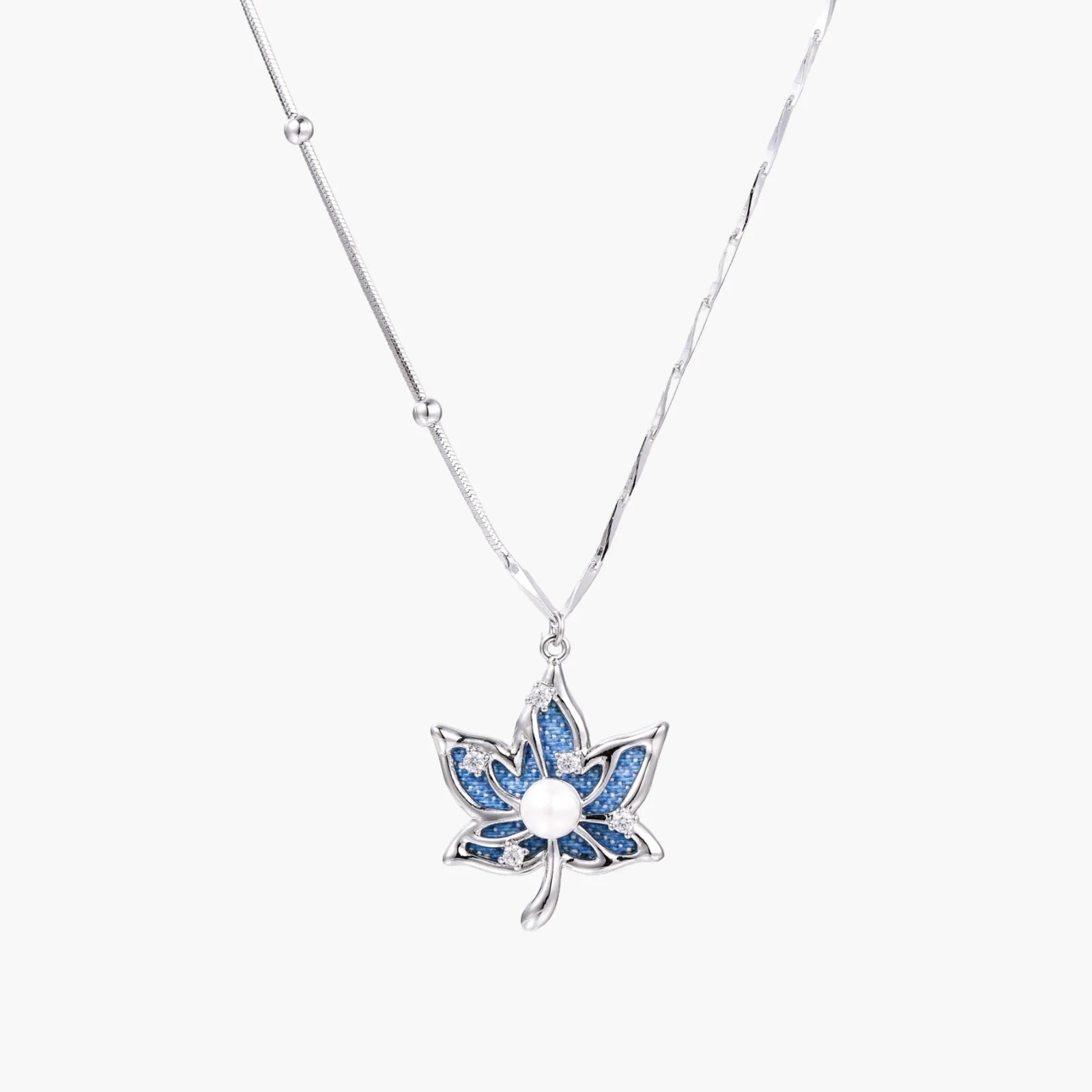White gold-plated lotus pendant with blue denim fabric inlay and sparkling zirconia stones on adjustable chain