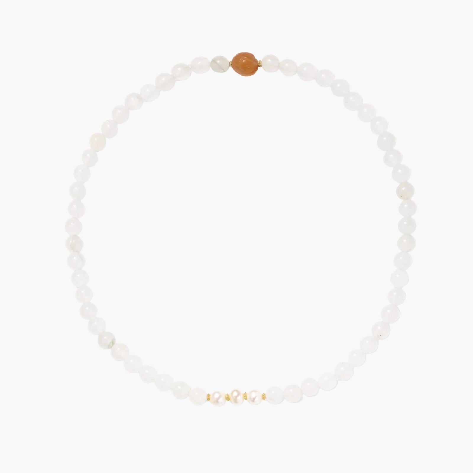 Three layered white beaded bracelets with carved orange agate lotus centerpiece and freshwater pearls on cream background.
