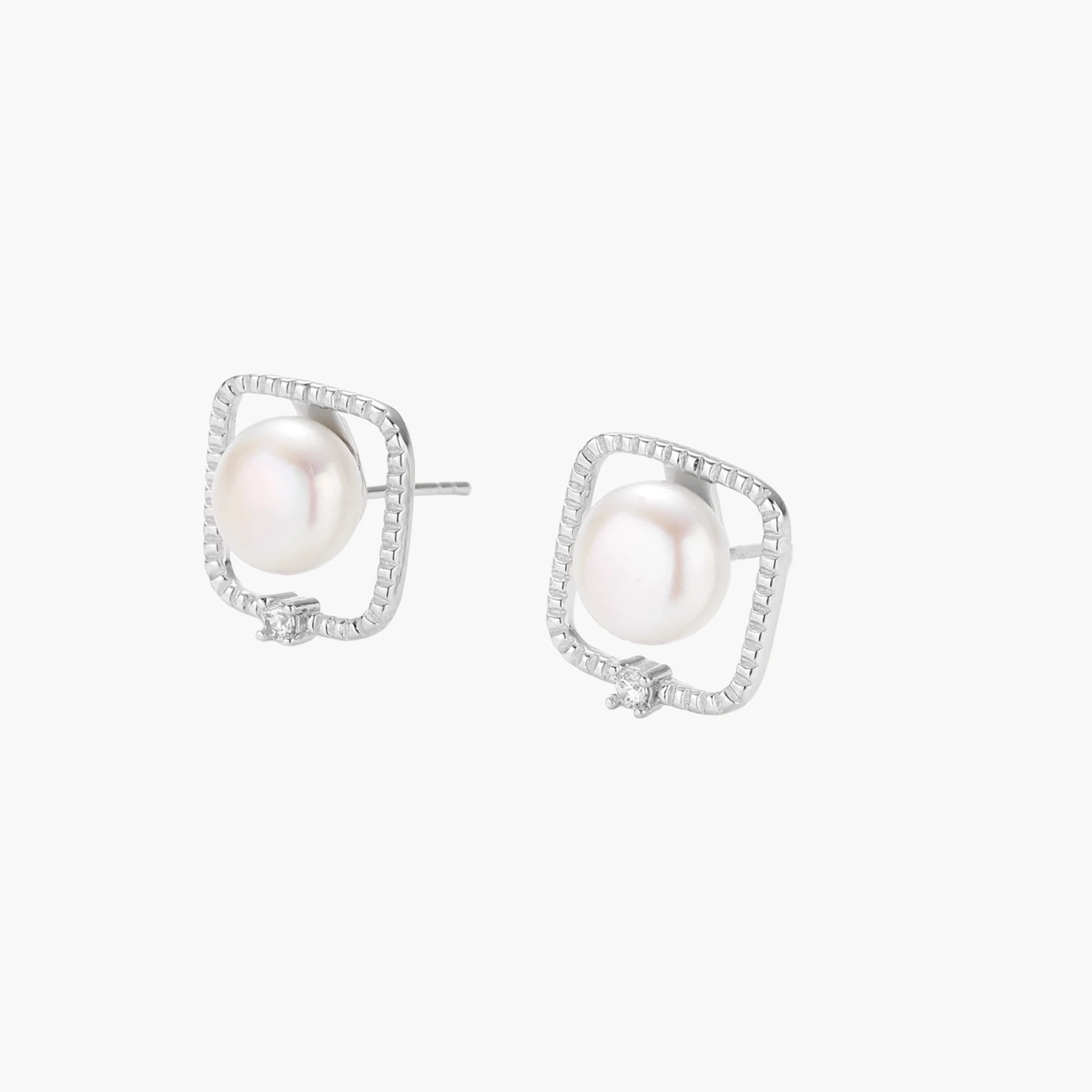 Rhodium-plated silver stud earrings with cushion frame, centered freshwater pearl, and tiny crystal accent