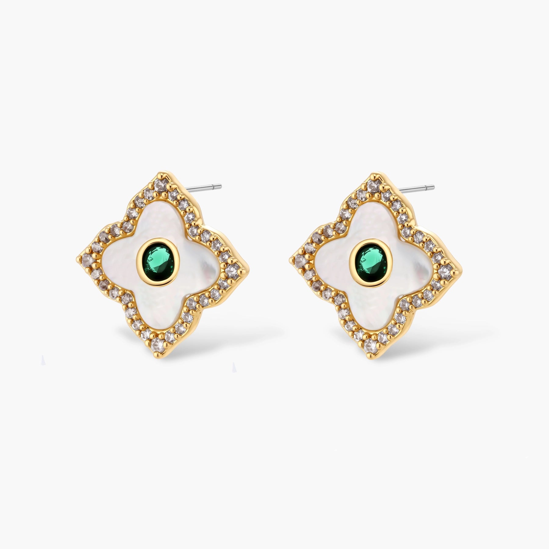 Gold-plated quatrefoil pendant and earrings with white enamel, emerald CZ center stones, and crystal borders on white background.
