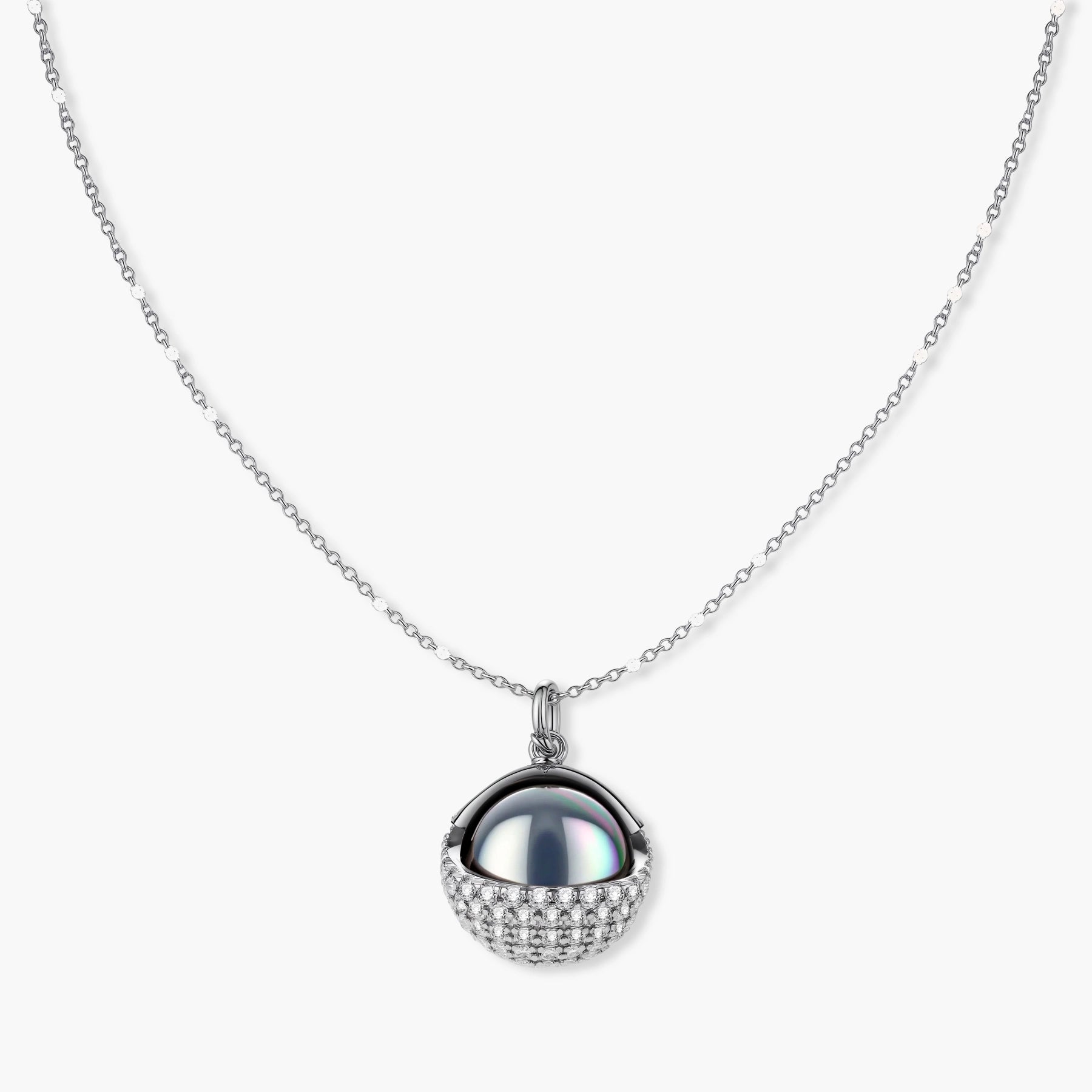 Elegant spherical pendant necklace and earrings set featuring crystal-pavé bottom half in gold or silver finish on white background.
