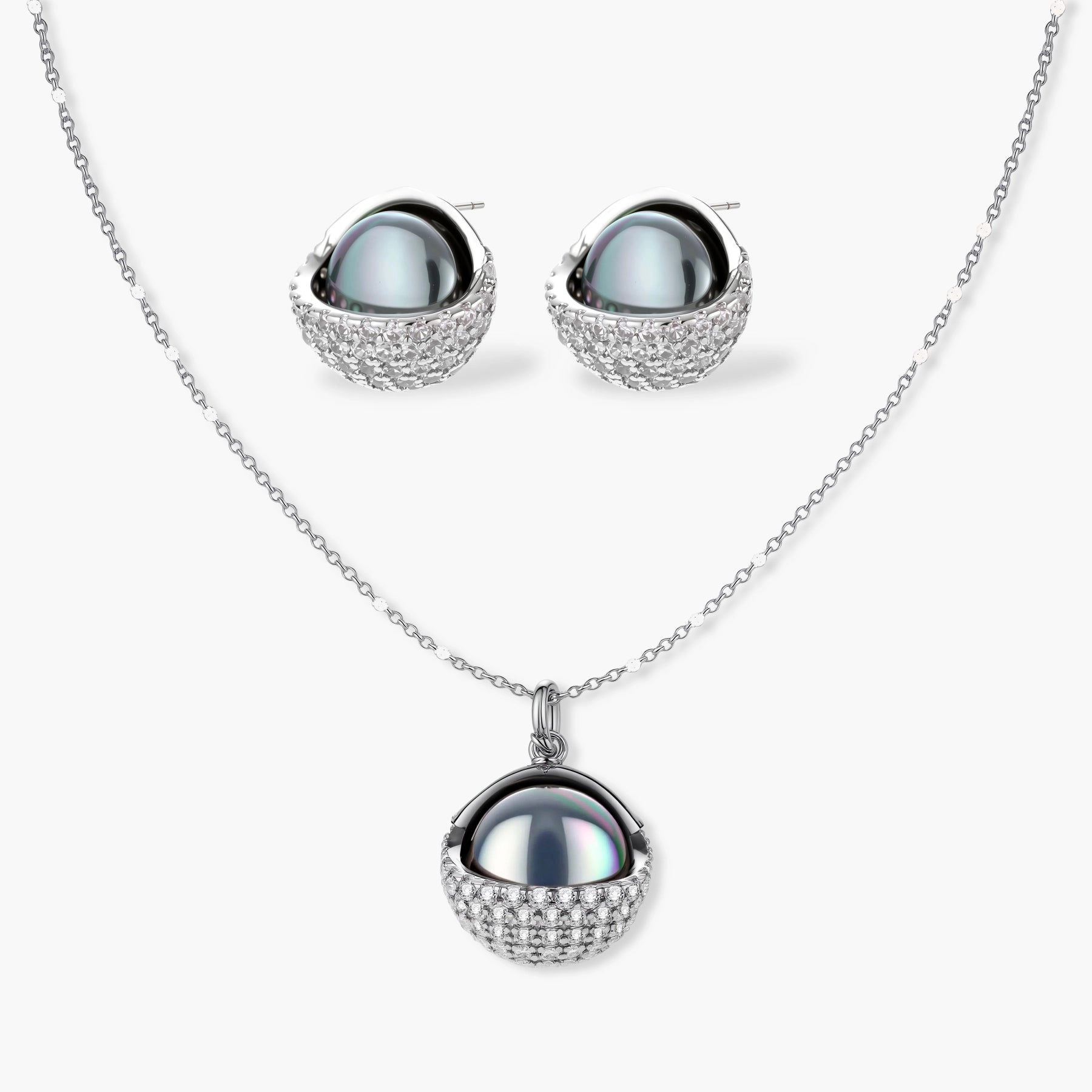 Elegant spherical pendant necklace and earrings set featuring crystal-pavé bottom half in gold or silver finish on white background.