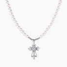 White pearl beaded necklace with ornate crystal-embellished cross pendant on white background, white gold plated finish