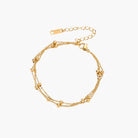 Three-strand gold-plated bracelet with clustered ball beads and adjustable clasp on cream background
