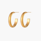 Chunky brushed gold hoop earrings in 14K plated stainless steel on cream background, front and side view.