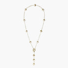 Gold-plated lariat necklace with baroque pearls and textured caps on cream background, showing adjustable Y-shaped design.