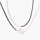Double-strand necklace with black faceted quartz and white pearls featuring an oversized baroque pearl centerpiece