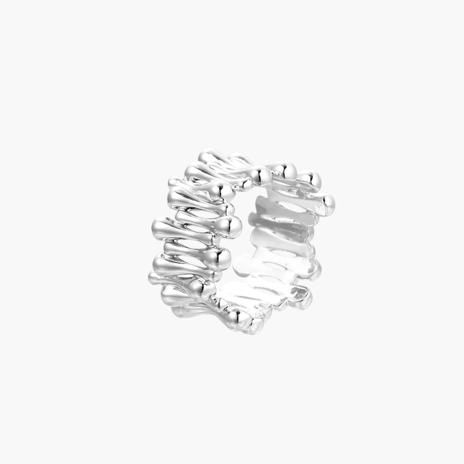 Wide band ring with sculptural wave ripples in polished white gold plated eco-brass on cream background