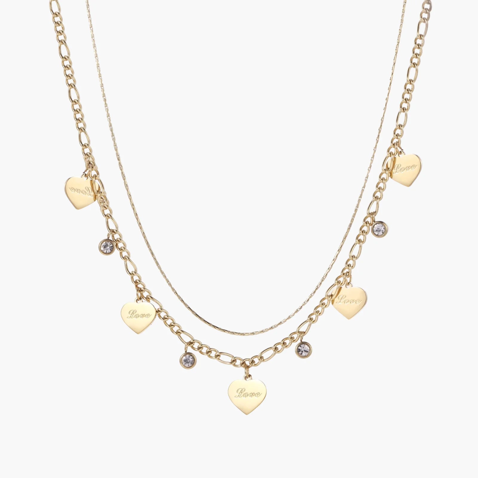 Gold layered necklace set with engraved heart pendants and crystal accents on cream background