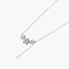 White gold plated Y-shaped necklace with three dimensional flower charms and adjustable drop pendant
