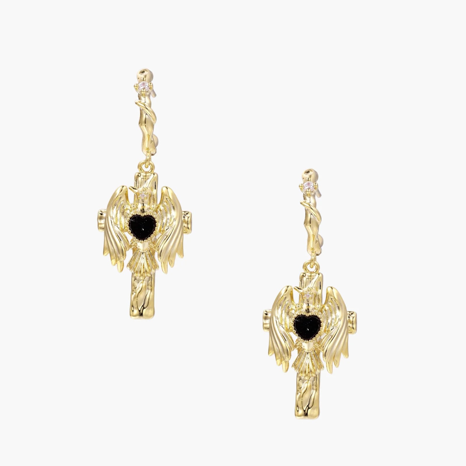 Gold angel wing drop earrings with black heart-shaped zirconia center and twisted posts on beige background