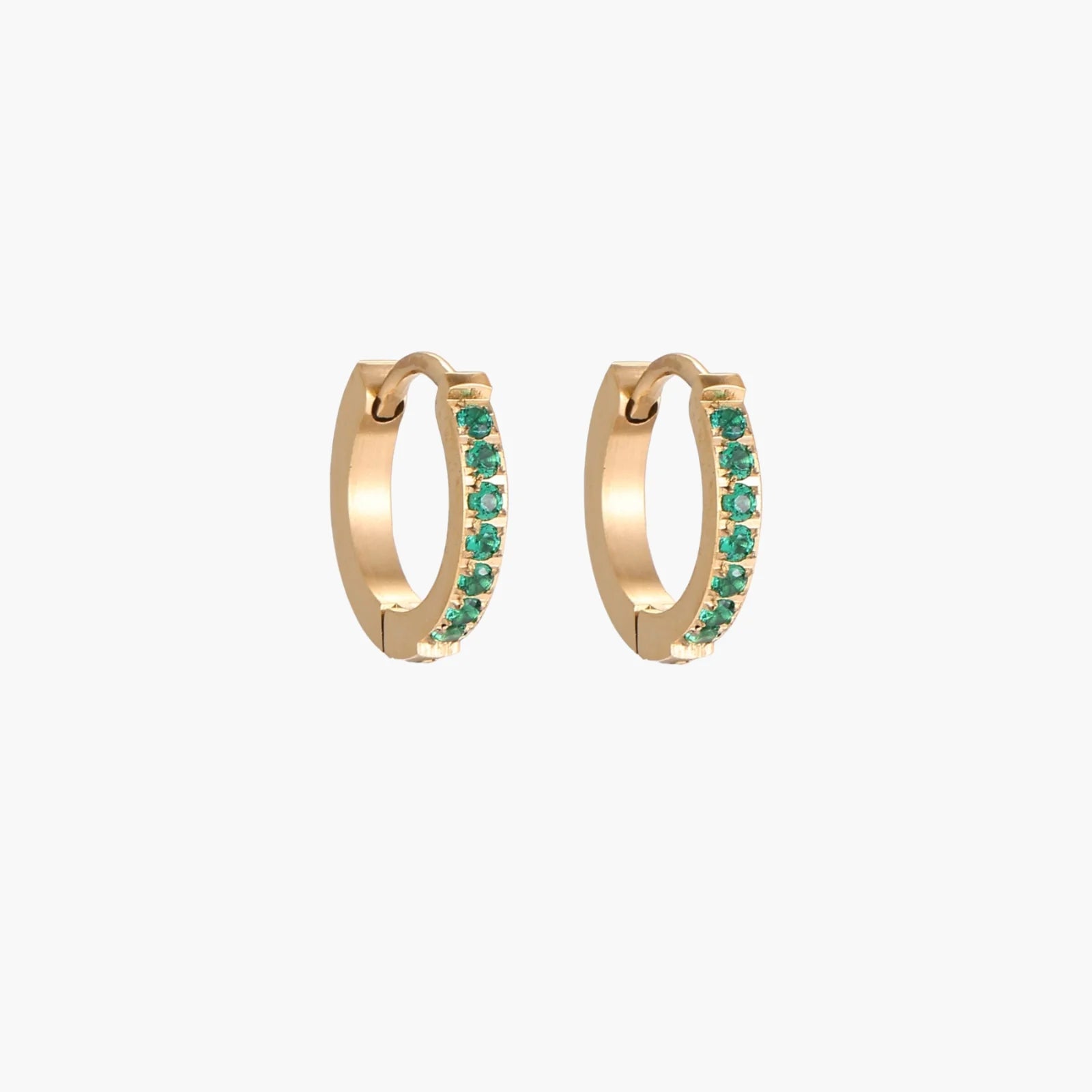 Pair of small gold huggie hoop earrings with bright green cubic zirconia stones on cream background