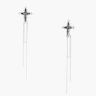 Long silver threader earrings with ornate cross-star design and delicate dual chain tassels on white background