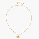 Layered necklace with green stone beads, gold spacers, white accents, and protective eye pendant on cream background.