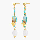 Gold-plated dangle earrings with turquoise threading, star charms, and white pearl beads against cream background.