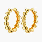 Close-up of gold-plated sterling silver hoop earrings with bamboo-inspired segmented design on white background.